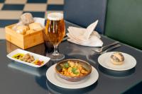 a table topped with plates of food and a glass of beer at Vila Gale Nautico in Armação de Pêra