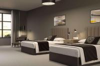 ein Hotelzimmer mit zwei Betten und einem Stuhl in der Unterkunft Riverbend Hotel and Suites, Trademark Collection by Wyndham in Ashtabula