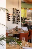 ein Esszimmer mit Tischen und Weinflaschen an der Wand in der Unterkunft hôtel restaurant le S'Y in Seingbouse