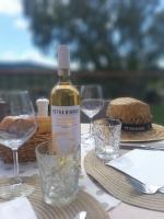 a bottle of wine sitting on a table with glasses at Tenuta Petra Bianca in Palau