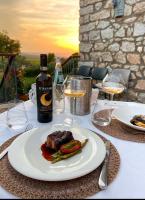 a table with a plate of food and a bottle of wine at Tenuta Petra Bianca in Palau