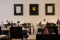 una sala da pranzo con tavoli e sedie con bicchieri da vino di Hotel Käenpesä a Ylivieska