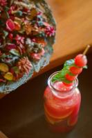 Una bebida en un frasco de vidrio junto a una pizza. en Tilar Siro Andamans - A CGH Earth Experience, en Isla Havelock