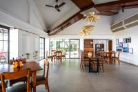 een eetkamer met houten tafels en stoelen bij The Lighthouse - Formerly known as Utan Sea Resort in Thane