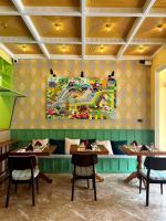 een restaurant met tafels en een schilderij aan de muur bij Senglao Boutique Hotel Luang Prabang in Luang Prabang