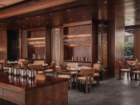 バンコクにあるNysa Hotel Bangkok Sukhumvit 11の木製の壁とテーブルと椅子が備わるレストラン