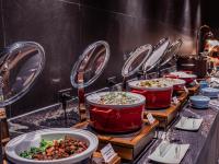 バンコクにあるNysa Hotel Bangkok Sukhumvit 11の赤い鍋に入ったたくさんの料理が並んだビュッフェ