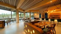 a restaurant with tables and chairs and windows at Giovanni Village Resort in Bhopal