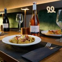 een bord eten op een tafel met wijnflessen bij Tranquillo UpTown Lecce in Lecce