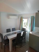 une salle à manger avec une table et des chaises blanches dans l&#39;établissement Camping du Lac, à Foix