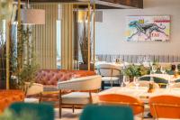 um restaurante com um sofá, mesas e cadeiras em Hotel Kocka Vrnjačka Banja em Vrnjačka Banja