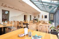 Un restaurante vacío con mesas y sillas de madera. en Hotel Ladenmühle, en Kurort Altenberg
