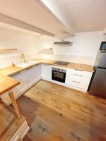 a kitchen with white cabinets and a sink and a refrigerator at Appartement + terrasse à 5min à pied de la mer et du Vallon des auffes in Marseille