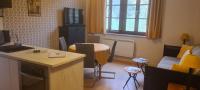 a small living room with a table and a kitchen at Le Porteur de Glace Classé 2 étoiles in Aulus-les-Bains