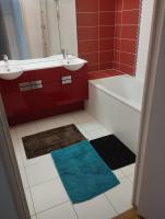 a red bathroom with a white sink and a bath tub at BEAU APPARTEMENT in Suresnes