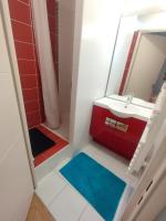 a bathroom with a red sink and a mirror at BEAU APPARTEMENT in Suresnes