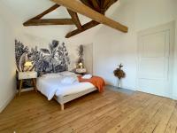 a bedroom with a bed and a wooden floor at Appartement Le Voltaire centre ville climatisé in Saumur