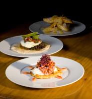 ジャクソンにあるThe Rusty Parrot Lodge and Spaの木のテーブルの上に置かれた3枚の皿の料理