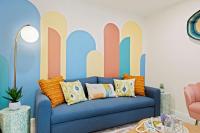 ein Wohnzimmer mit einem blauen Sofa vor einem Wandbild in der Unterkunft New Luxury Listing! August sale! in Destin