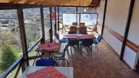 ein Balkon eines Restaurants mit Tischen und Stühlen in der Unterkunft Pensiunea Cabana Veverita Valea Doftanei in Trăisteni