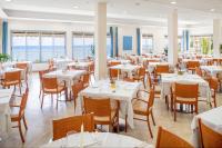 Un comedor con mesas y sillas blancas. en Hotel Metropol, en Diano Marina