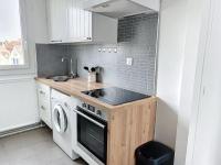 a kitchen with a stove and a sink and a washer at Le Raphaëlle - Compiègne centre in Compiègne