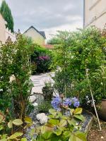 a garden with flowers and trees in a yard at Villa Einigriv in Châtelaillon-Plage