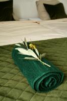 a green towel with a flower on a bed at Le Clos des Laurons in Nyons