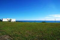 a white building on top of a grass field at The Blue Lagoon B&amp;B in Fengbin