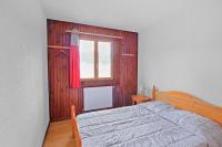 a bedroom with a bed and a window at Appartement CERF in La Llagonne