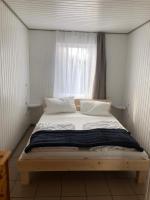 a bed in a small room with a window at Gast-&amp; Logierhaus Am Rheinsberger See in Rheinsberg
