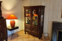 a large wooden cabinet with a lamp next to a table at Gîte Ty Maen à Plouhinec (56) 4 in Plouhinec