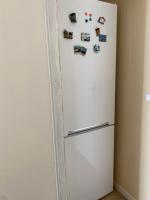 a white refrigerator in a kitchen with magnets on it at ila’s tiny house in Limoges