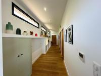 a hallway of a house with white walls and wooden floors at Villas de standing avec magnifique vue mer et piscines privées, Sagone in Sagone