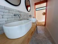 a bathroom with a large white tub and a sink at Villas de standing avec magnifique vue mer et piscines privées, Sagone in Sagone