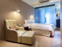 a bedroom with a bed and a couch and a chair at Hotel Relax I in Taipei