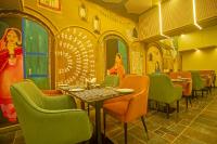 a restaurant with tables and chairs and a painting on the wall at Amritara Maa Katra in Katra