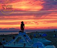 a person standing on the beach at sunset at Les Pieds dans le Sable in Le Grau-du-Roi