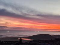 un tramonto sull'oceano con una montagna in lontananza di DAN EN WAN a Oesterbaai