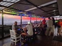 un gruppo di persone seduti in un bar su un ponte di DAN EN WAN a Oesterbaai