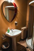 a bathroom with a sink and a mirror and a toilet at Pensiunea Casa Soarelui in Podu Dîmboviţei