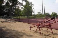 a red bench on a tennis court next to a playground at Le Buisson in Montlouis-sur-Loire