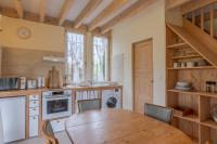 a kitchen with a wooden table and a dining room at Les Treilles de Razac in Razac-de-Saussignac