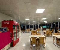 un ristorante vuoto con tavoli e una macchina per la coca-cola di HOTEL YAGMUR a Anamur
