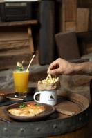 AndacolloにあるHotel y Restaurant Doña Rodeの人がコーヒーカップでフライドポテトを食べている