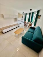 a living room with a green couch and a table at Msida Central Suites in Msida