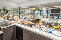 a buffet line with food in a restaurant at Au Comté d&#39;Ornon Hôtel &amp; Spa in Gradignan