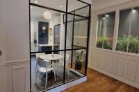 a glass room with a table and chairs in it at Magnifique appartement de charme au cœur de Paris in Paris