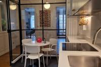 a kitchen with a table and chairs and a sink at Magnifique appartement de charme au cœur de Paris in Paris
