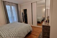 a bedroom with a bed and a large mirror at Magnifique appartement de charme au cœur de Paris in Paris